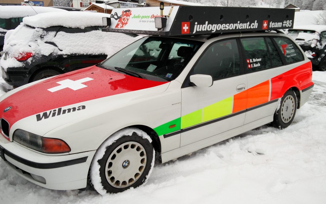Das Rallye-Auto «Wilma» im Schnee, beklebt mit Schweizer Flagge und Startnummer